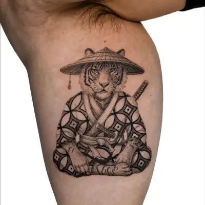 Tattoo of tiger in kimono with hat and sword on thigh.