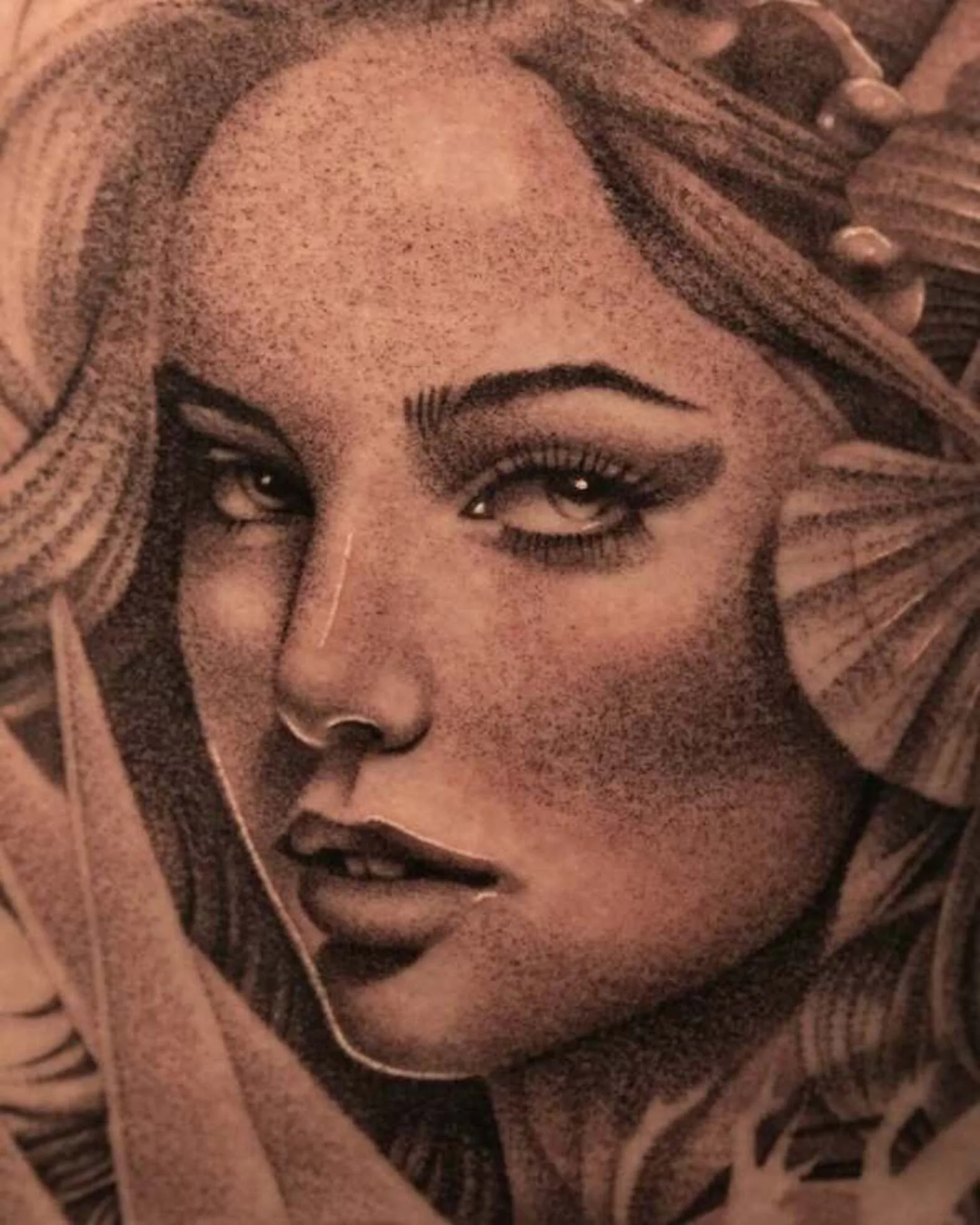 Black and grey tattoo of a woman's face with detailed shading.