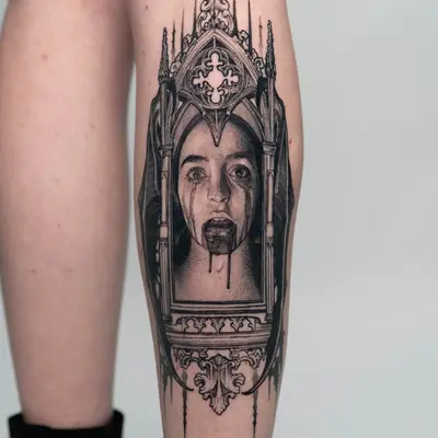 Realistic tattoo of a woman's face in a Gothic frame on a leg.