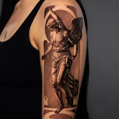 Black and grey tattoo of a winged angel in classical attire on upper arm
