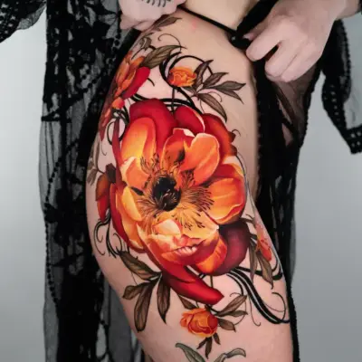 Large floral tattoo on thigh with orange and red flowers.