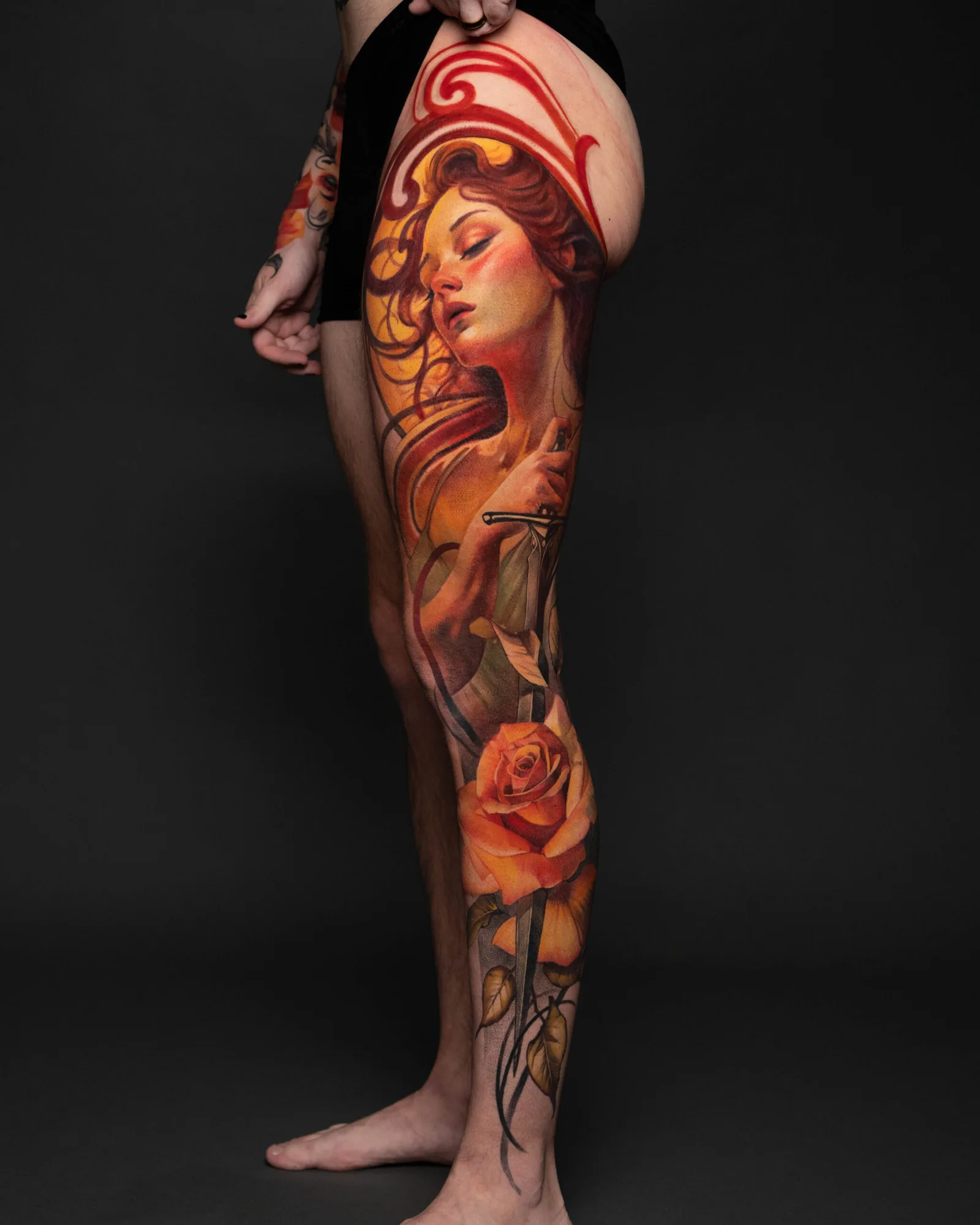 Colorful leg tattoo with a woman's face and orange rose.