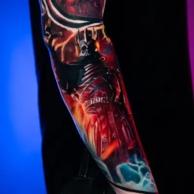 Colorful sleeve tattoo featuring a dark, armored character and a red butterfly.