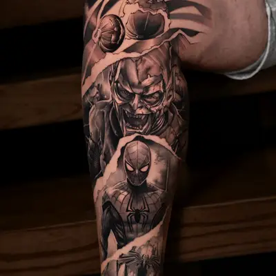 Black and grey realism tattoo down a lower leg with pumpkin bombs at the top, the Green Goblin in the middle and Spider-Man below, divided by torn paper edges.