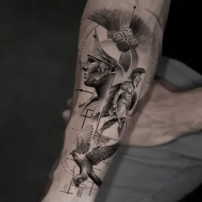 Black and grey forearm tattoo of a crested helmet in profile with a standing warrior figure and a bird in flight near the wrist.