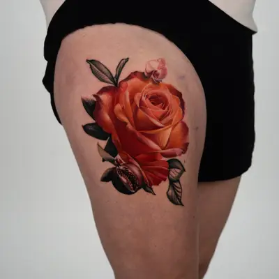 Large orange rose with a split pomegranate and an orchid bud on a thigh, blooms in full color and the leaves in black and grey.