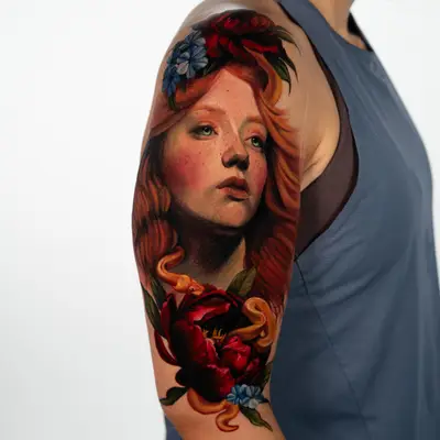Color realism portrait of a red-haired woman with green eyes on an upper arm, crowned with red peonies and blue cornflowers, a gold snake winding down through the flowers.