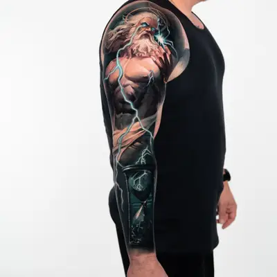 Full sleeve of Zeus wreathed in lightning across the shoulder, with an hourglass on the forearm holding lightning inside the glass.