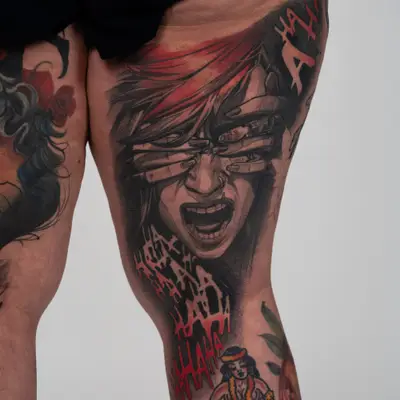 Healed tattoo on the back of the right thigh of Violet from the series Arcane with long-nailed hands pressed over its eyes, a sweep of red hair across the top, and dripping red and black HA HA lettering running down toward the knee.