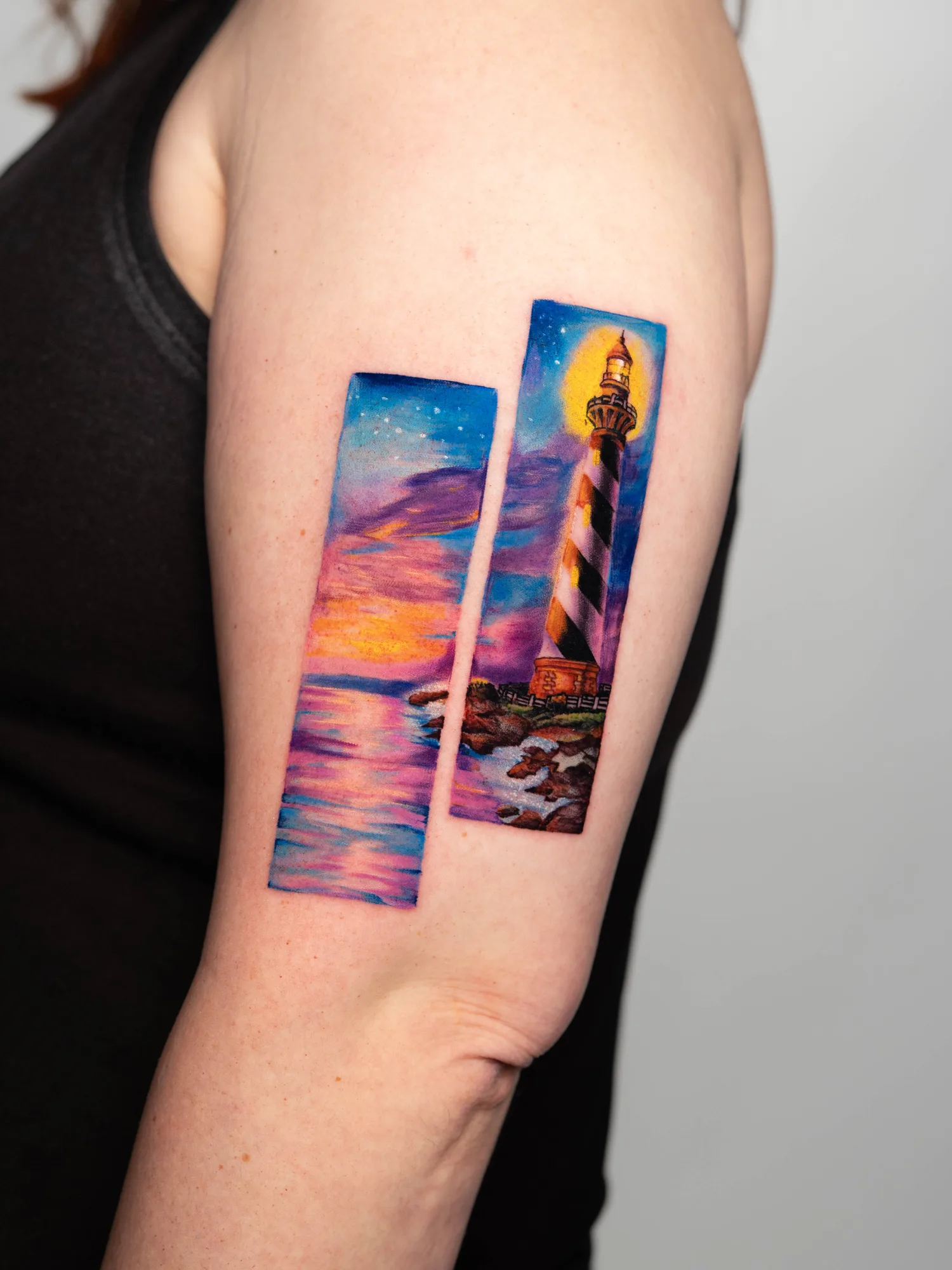 Colorful tattoo of a lighthouse with a sunset, split into two rectangular sections on an arm.