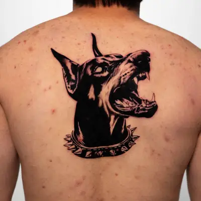 Tattoo of a dog's head on upper back.