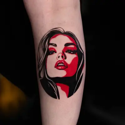 Tattoo of stylized woman's face in red and black