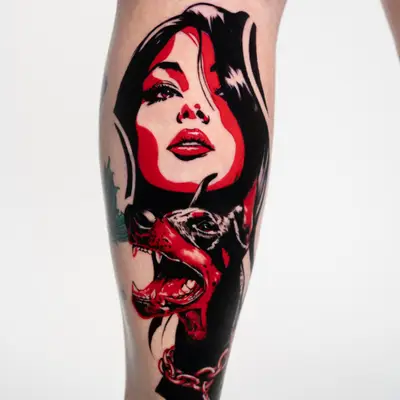 Tattoo of a woman's face and a growling dog in black and red ink.