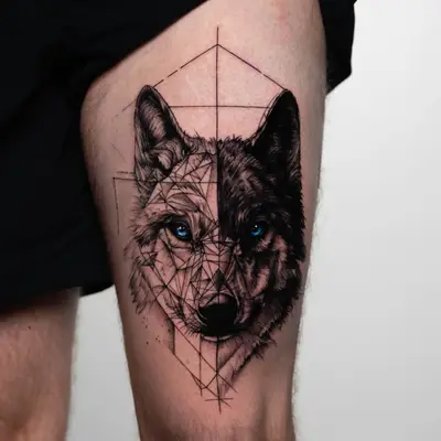 Geometric wolf tattoo with blue eyes on upper thigh.