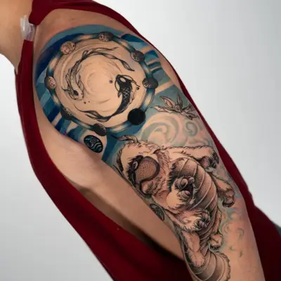 A colorful tattoo featuring aquatic elements and a creature on the upper arm.