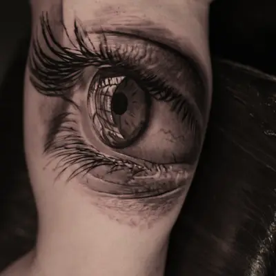 Realistic eye tattoo on inner arm