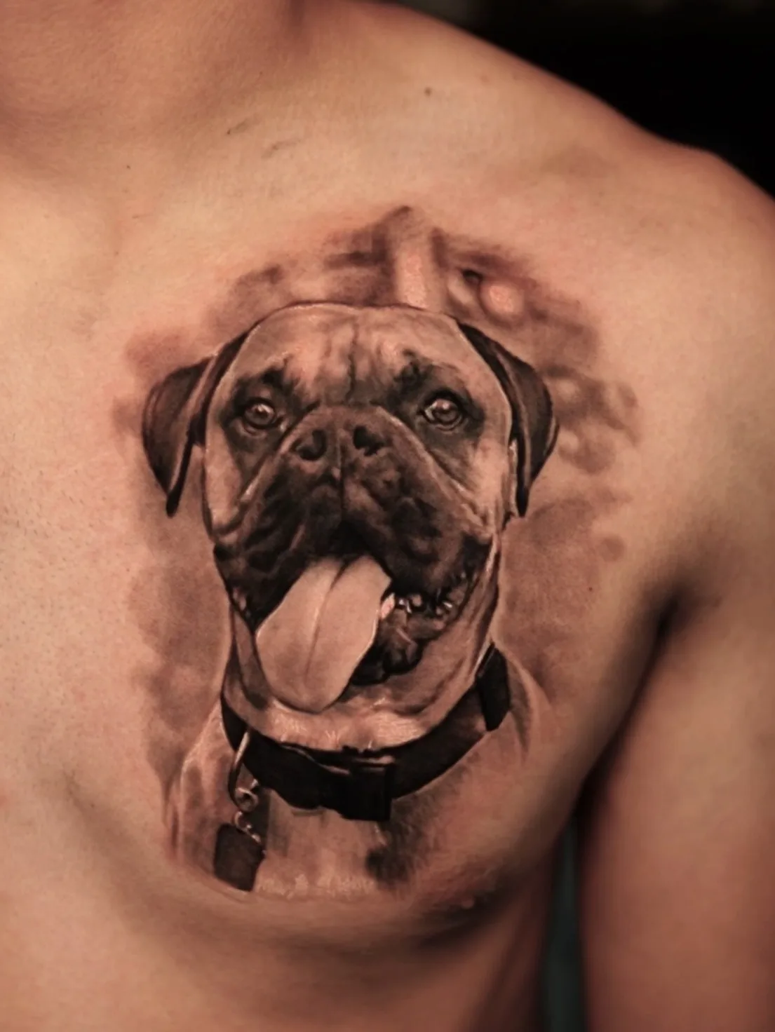 Realistic dog portrait tattoo on upper chest