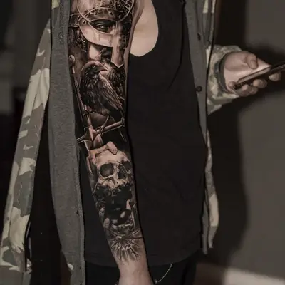 Realistic sleeve tattoo with Norse warrior, raven, and skulls