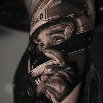 Tattoo of a race car driver wearing a helmet on an upper arm.