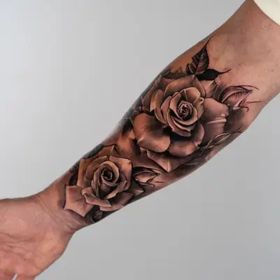 Black and grey realism rose tattoo on a forearm. 