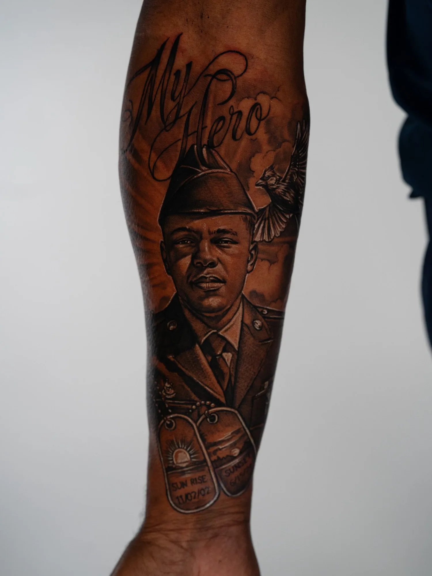 Black and grey realism portrait of a soldier with dog tags and bird, captioned 'My Hero.'