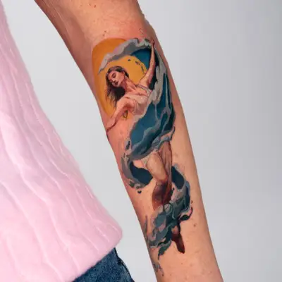 An illustrative realism tattoo on the outer forearm of a woman with flowing wave accents and a sun in the background.