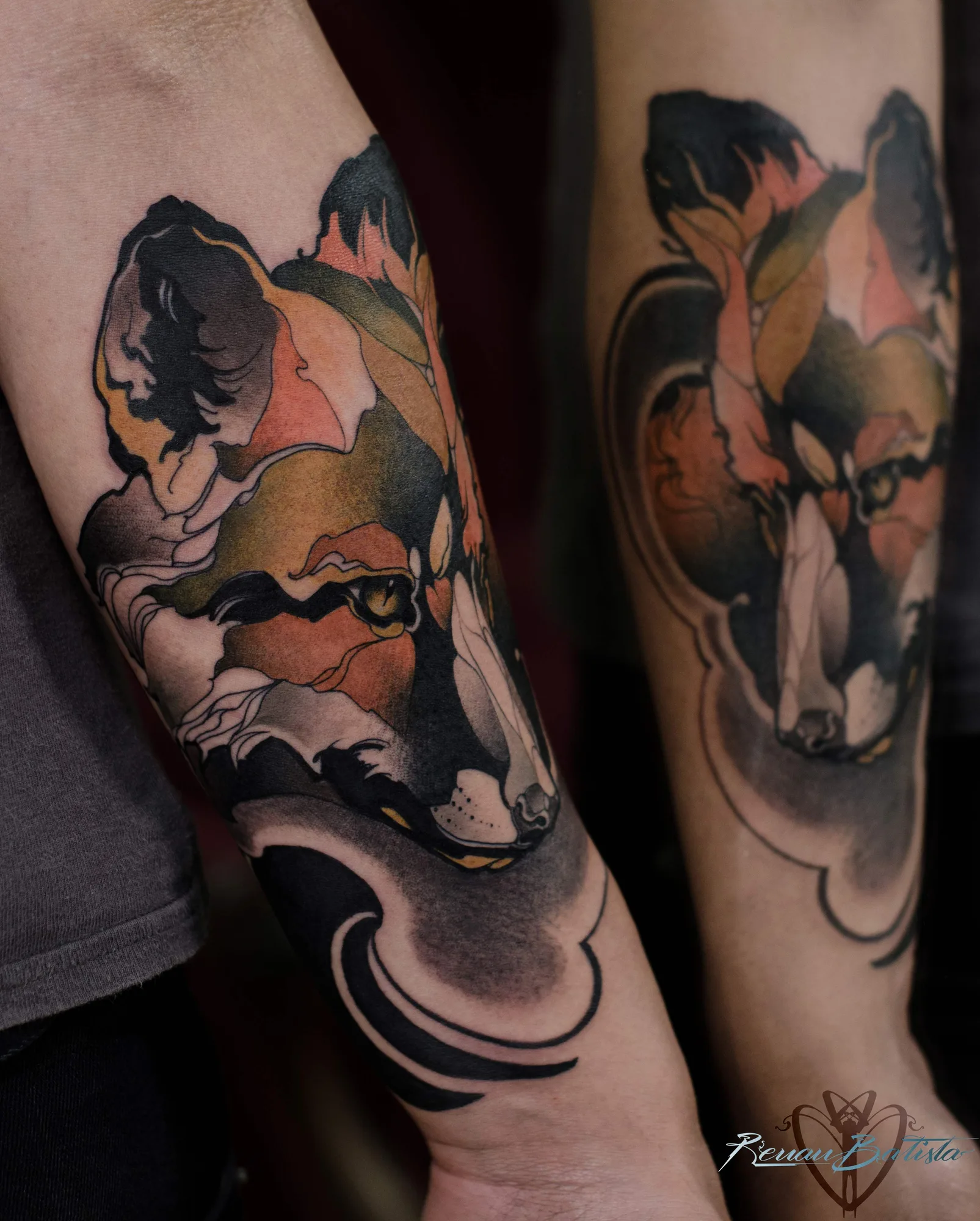 Two color neo-traditional fox heads on two forearms, side by side, in rust, ochre, moss green and black: one finished with a sweeping black wave at the wrist, the other inside a thin outlined frame.