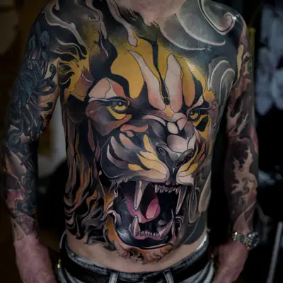Large chest tattoo of a roaring lion with abstract elements and bold colors.