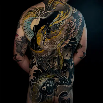 Full back tattoo of a golden snake coiling from the shoulders down to the hips, locked with a winged golden bird across the middle of the back, against a dark background of black wind, flame and wave shapes.