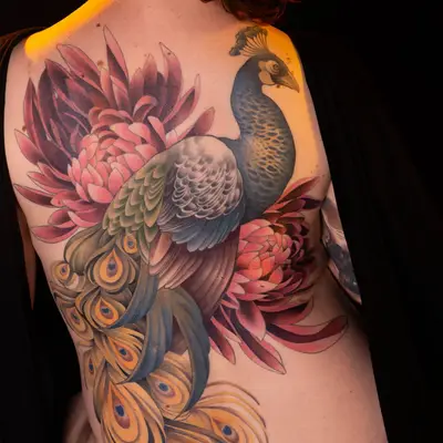 Colorful peacock tattoo covering woman's back.