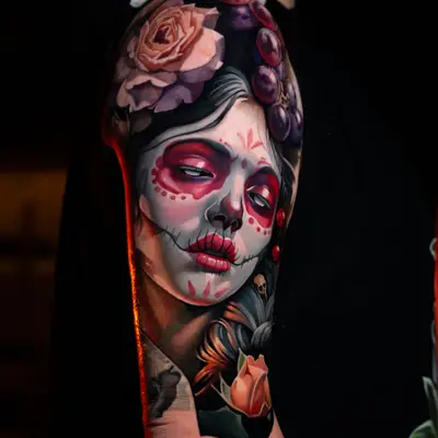 Color realism tattoo of La Catrina with roses on a shoulder and upper arm