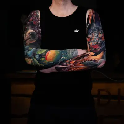 Collector wearing two full color realism sleeves of fruit, animals and a dragon
