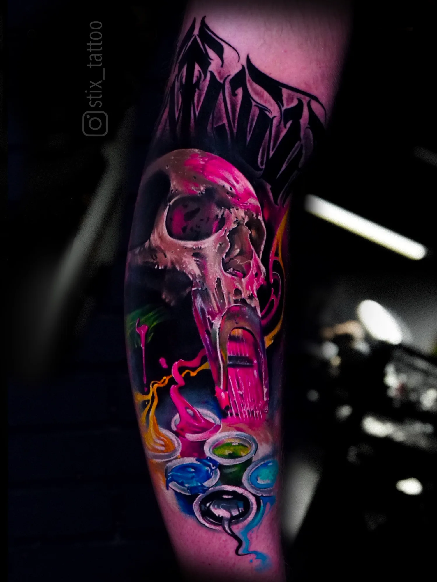 Colorful skull tattoo with paint splash effects on arm