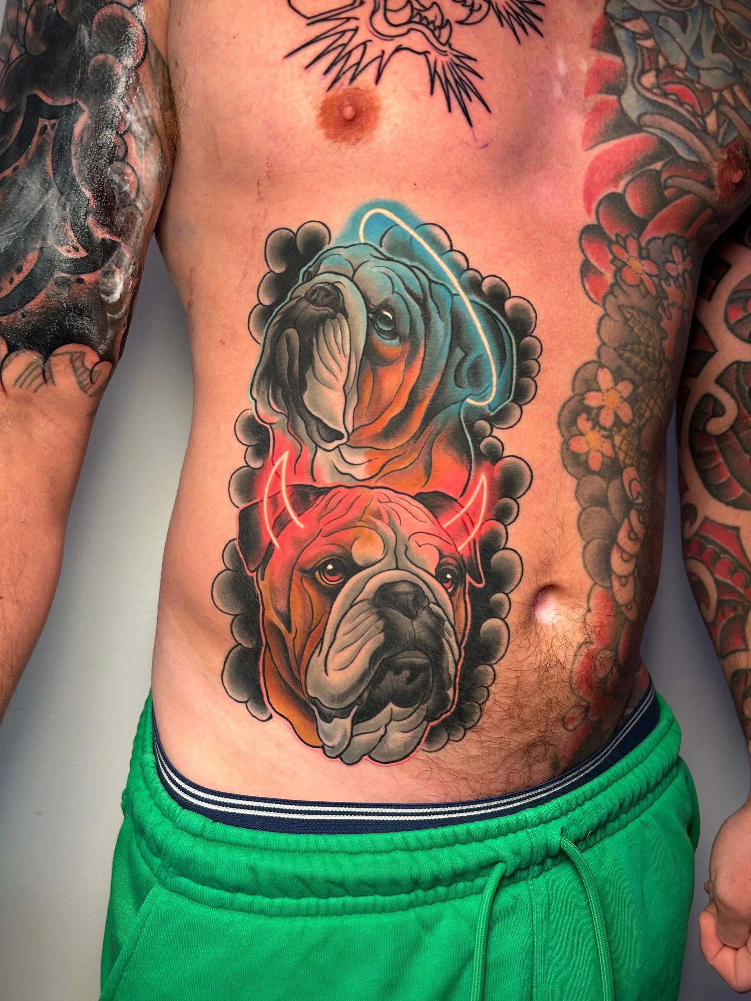 Colorful bulldog tattoo with neon horns and halos on the torso.