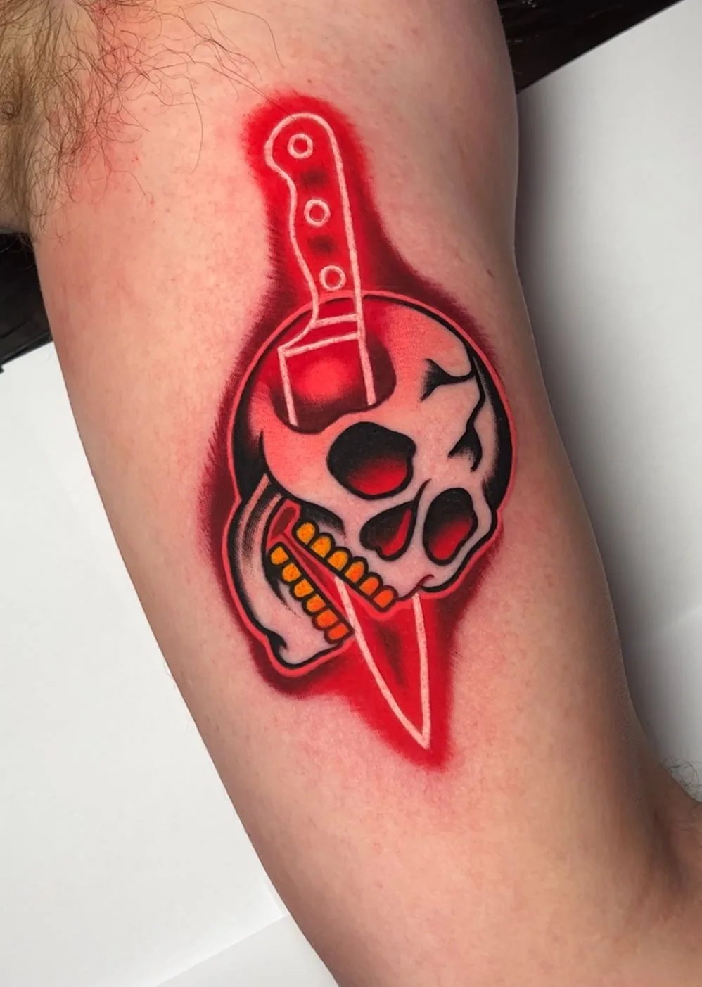Skull with a knife through it, featuring bold colors and shading.