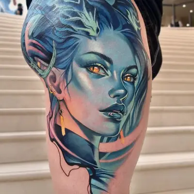 Colorful portrait tattoo of a woman with blue hair and striking horns and elvish features on the thigh.