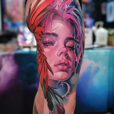 Realistic tattoo of a woman's face with colorful crystal and feather elements.