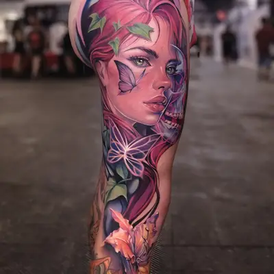 A vibrant leg sleeve tattoo of a woman with pink hair, butterflies, and flowers on a thigh.