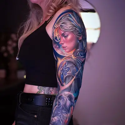 Colorful full sleeve tattoo featuring a portrait of a warrior goddess and a rabbit.