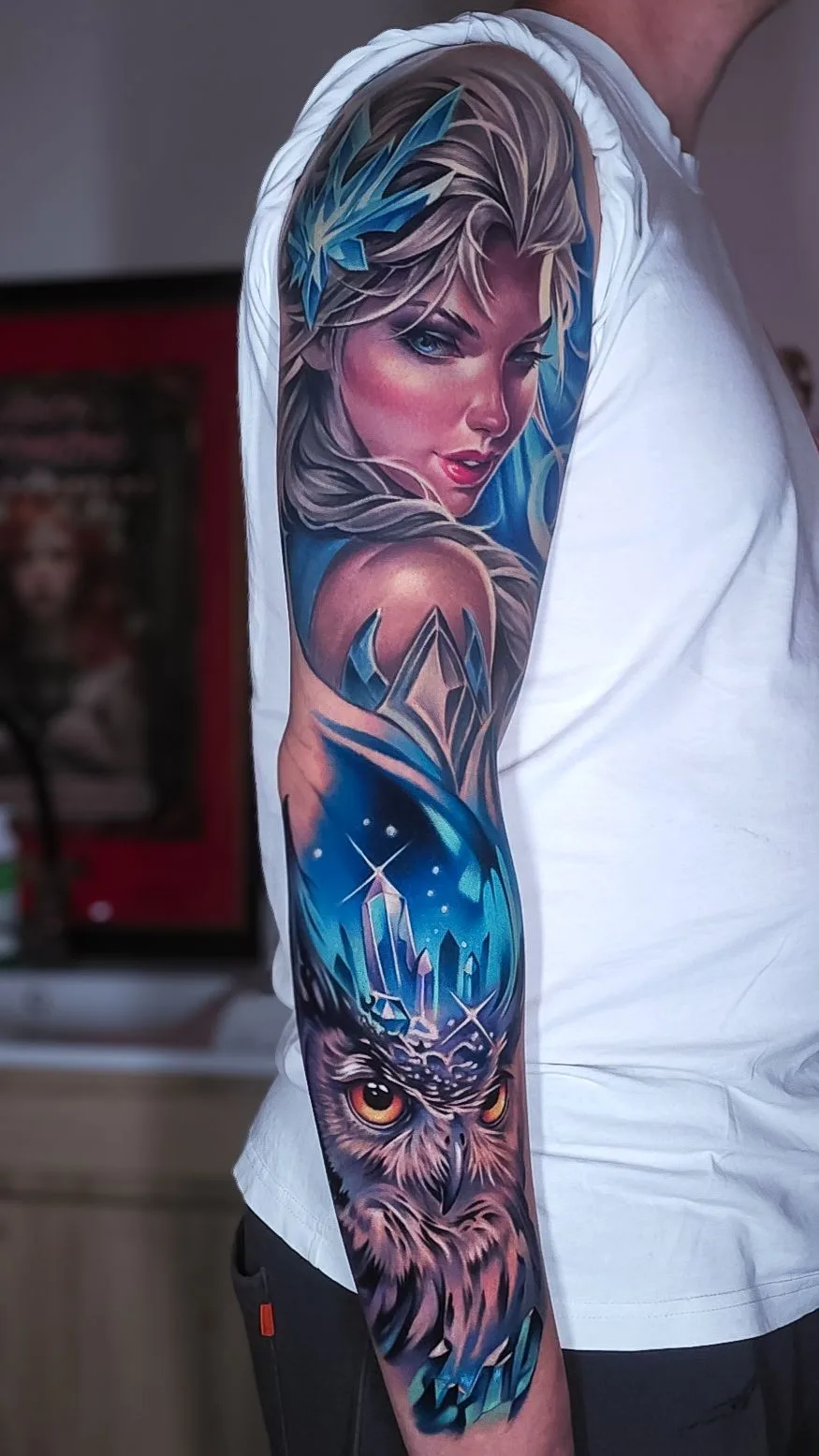 Full sleeve tattoo with a portrait of queen with gemstones and an owl with an icy blue theme.