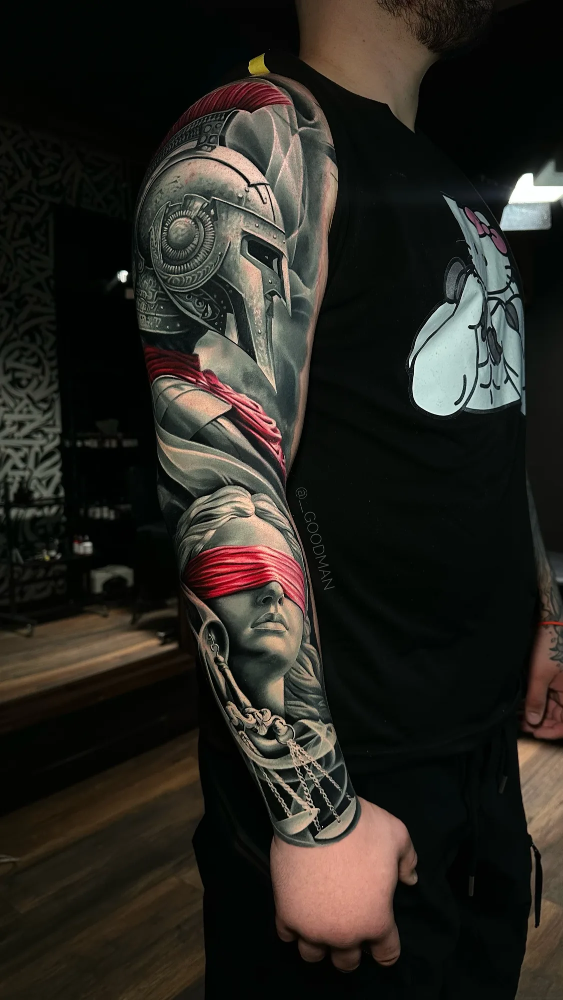 Tattoo of Spartan helmet and blindfolded Justice figure full sleeve