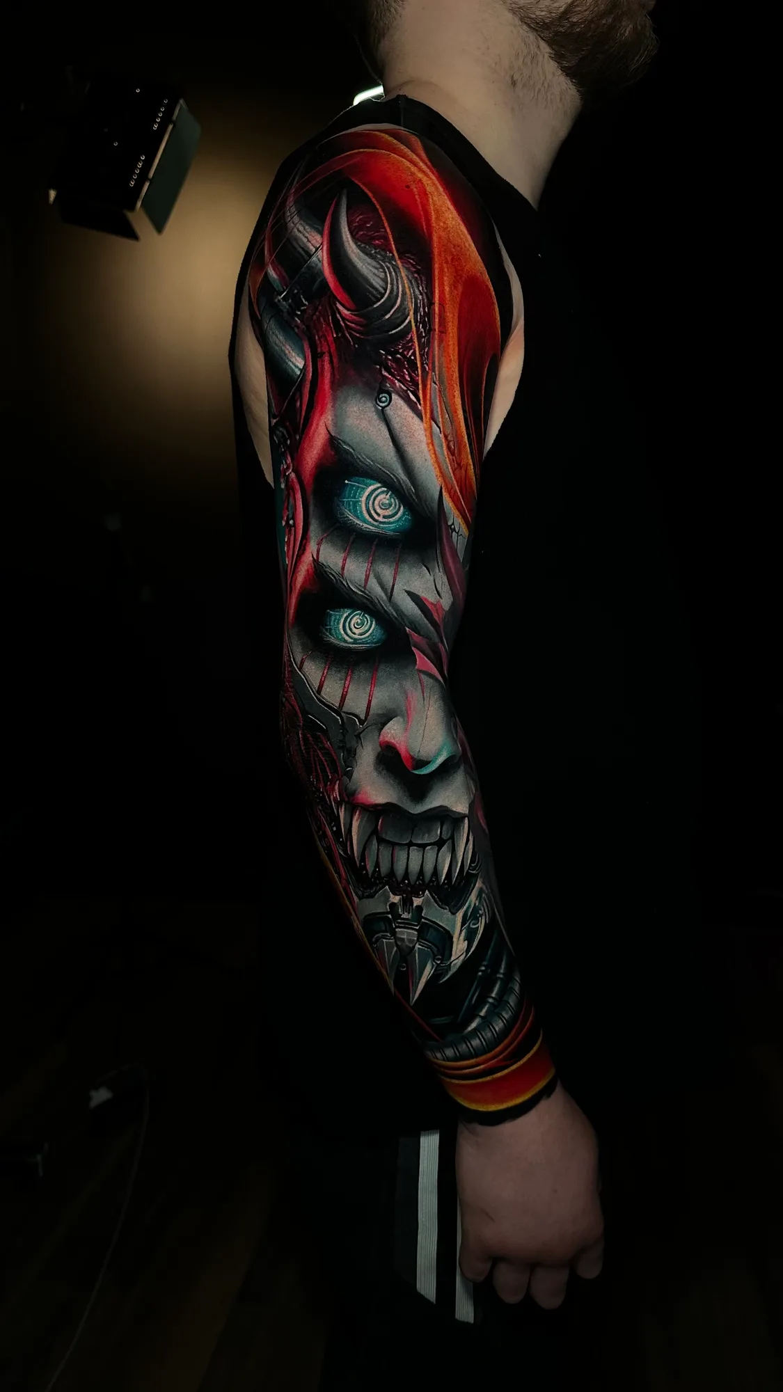 Full sleeve tattoo of a demonic face with vibrant colors
