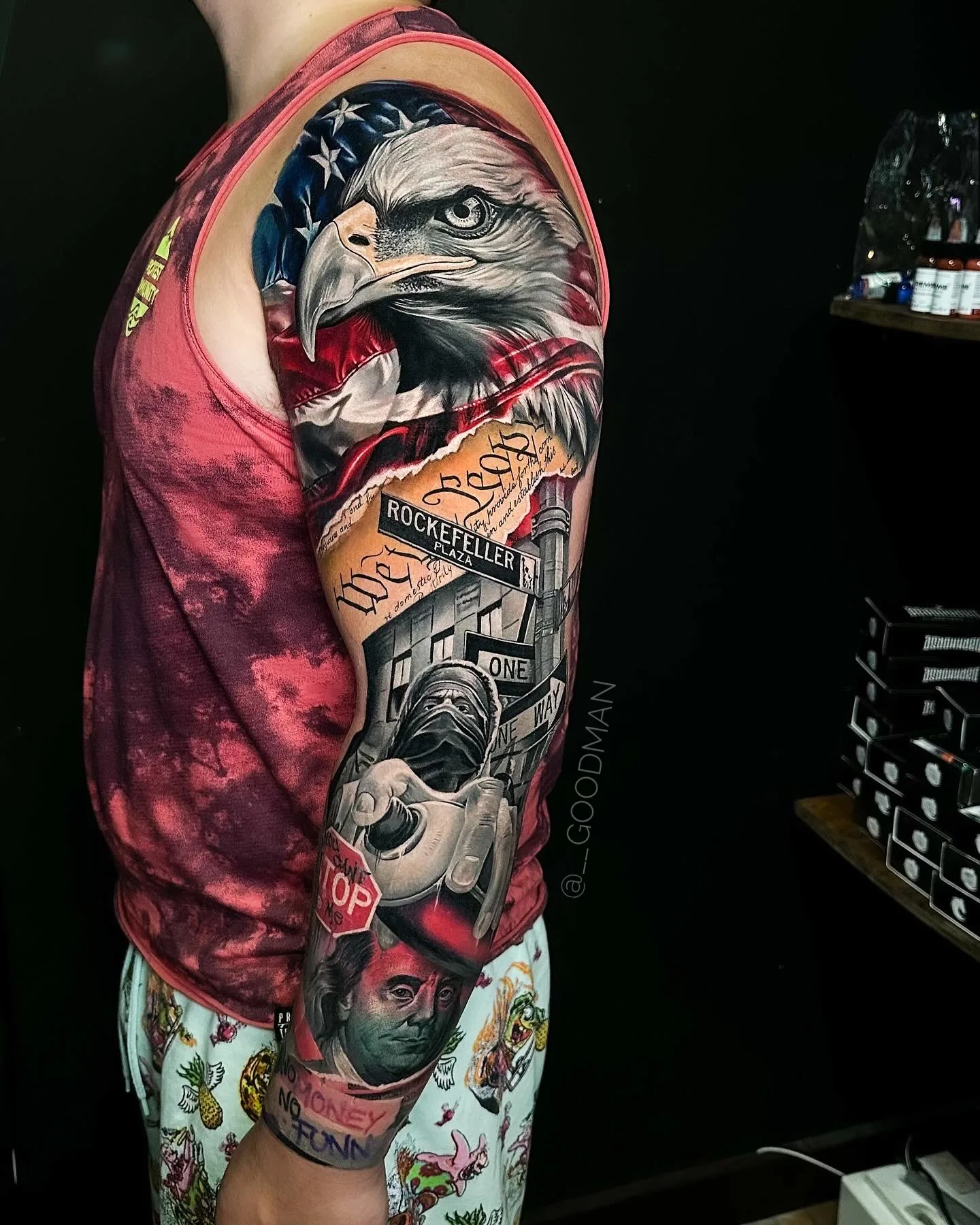 Full sleeve tattoo of eagle, American flag, and various symbols.