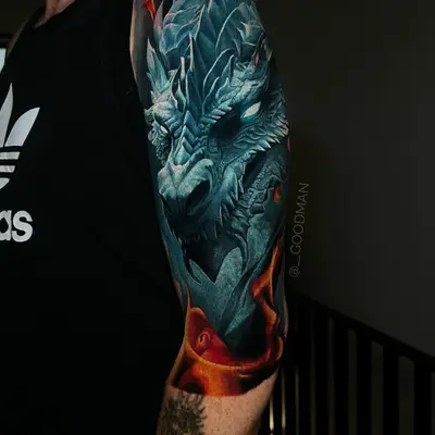 Blue dragon tattoo with fiery background on upper arm.